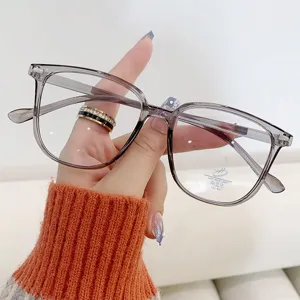 Detailansicht einer Hand mit stilvoller quadratischer Anti-Blaulicht-Brille in Transparentgrau