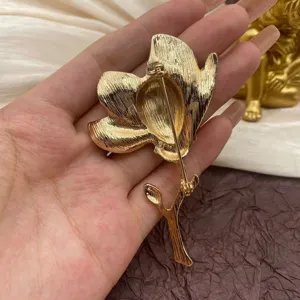 Close-up back view of a vintage gold tulip flower brooch showing the pin fastener.