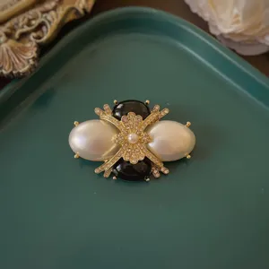 Spilla barocca vintage con perle bianche e dettagli in smalto nero su base metallica
