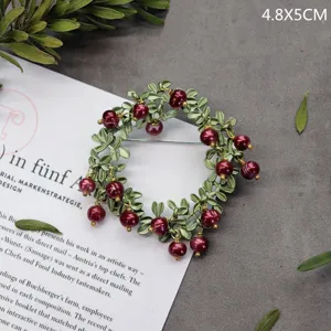 Prachtige elegante vintage broche in bosstijl met groene bladeren en rode bessen