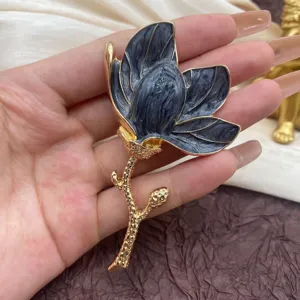 Macro view of a vintage tulip enamel brooch featuring black marble petals and gold stem