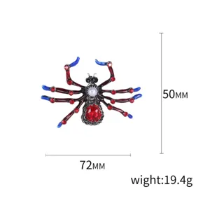 Detailed view of a vintage spider brooch with red rhinestones and 72x50mm measurements