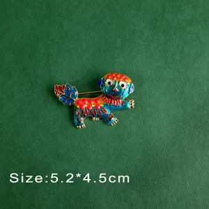 Close-up of vintage enamel mythical creature brooch with intricate colorful patterns
