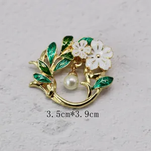 Detailed view of vintage floral brooch with white enamel petals and elegant pearl drop