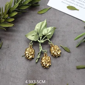 Detailopname van vintage bosstijl plantenbroche met groene bladeren en bessen