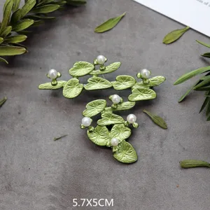 Detailopname van een vintage groene bladbrosche in bosstijl met parelelementen