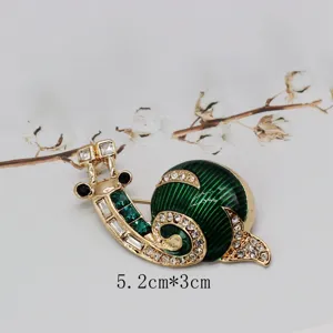 Detail of vintage snail brooch with green enamel and crystals, 5.2cm x 3cm.