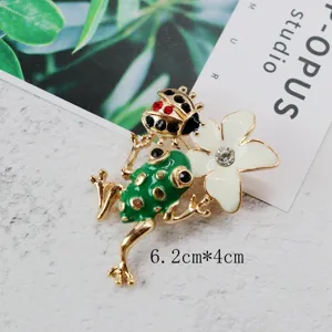 Close-up view of vintage green frog and white flower enamel brooch with 6.2cm x 4cm size