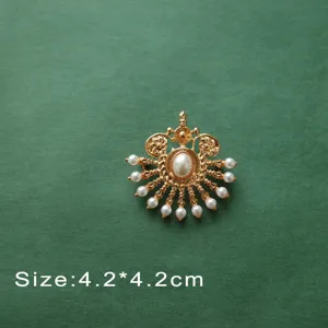 Close-up of vintage Baroque gold brooch with elegant white pearl details and crown motif