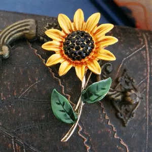 Detail van vintage emaille zonnebloem broche met een sprankelend zwart strass middelpunt