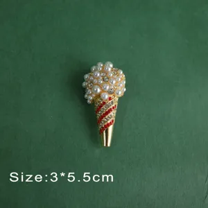 Macro view of vintage baroque ice cream brooch with pearls and red rhinestones