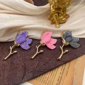 Close-up of elegant vintage tulip enamel brooches in purple, pink, and grey finishes.