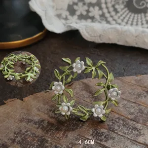 Detailed view of vintage lily of the valley enamel brooch with green leaves and pearls