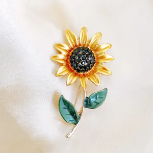 Detailopname van een vintage zonnebloemspeld met gele blaadjes en zwarte strass op zijde