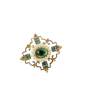 Vintage gold brooch with green emerald stone and pearls on white background