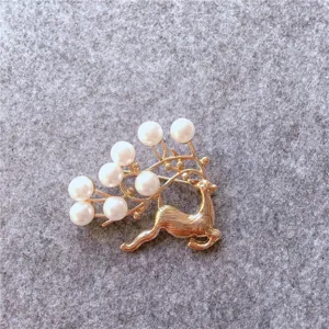 Close-up macro view of a vintage golden reindeer brooch featuring elegant white pearls