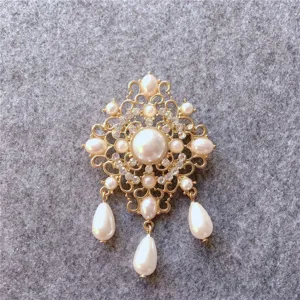 Close-up of vintage gold-tone brooch with elegant pearls and sparkling crystals