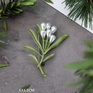 Detailweergave van de textuur van een vintage groene plantenbroche met witte parels, 6x4,5 cm.