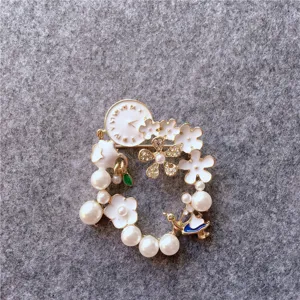 Detailed macro shot of vintage Alice in Wonderland theme floral pearl wreath brooch pin