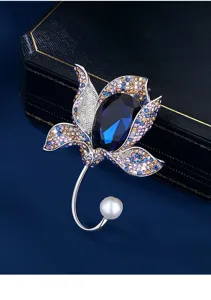 Close-up of an elegant vintage flower brooch featuring a blue crystal and pearl