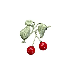 Elegante vintage kersenbroche in bosstijl met rode emaille kersen en groene bladeren