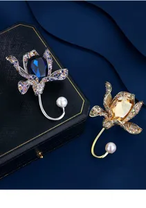 Elegant crystal flower brooches in blue and amber variants with pearl accents.