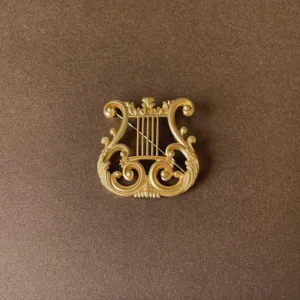 Detailed macro view of vintage baroque gold harp brooch with ornate filigree scroll design