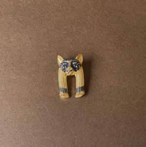 Close-up of vintage Baroque fox enamel brooch with detailed gold texture and blue inlay