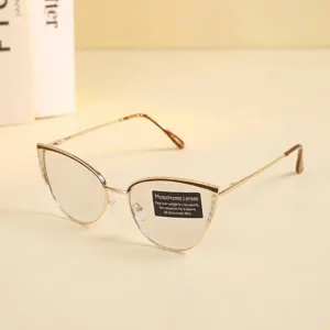 Detalle de gafas fotocromáticas de ojo de gato con montura de metal dorado y adhesivo.