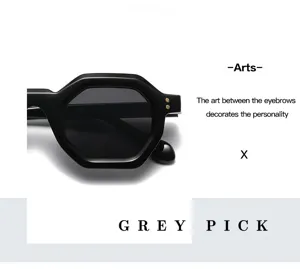 Detailaufnahme einer schwarzen sechseckigen Sonnenbrille mit Goldnieten auf weißem Grund.