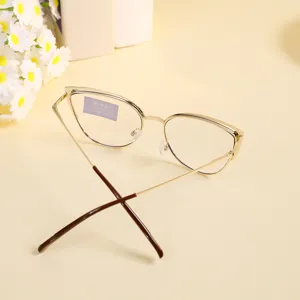 Primer plano de gafas cat-eye retro con montura de metal dorado y cristales transparentes