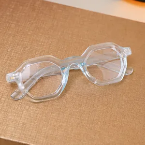 Detailansicht der stylischen transparenten Polygon-Brille auf goldenem Hintergrund