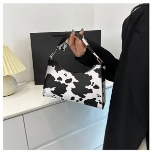 Detailed view of stylish cow print underarm bag with black and white pattern for women