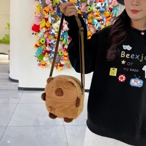 Vue détaillée d'un joli sac à bandoulière en peluche Capybara marron porté par un modèle chic