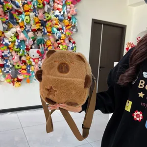 Vue détaillée d'un sac bandoulière en peluche capybara marron avec un visage brodé