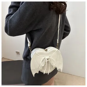 Achteraanzicht van een model met een witte hartvormige crossbodytas met vleermuisvleugels