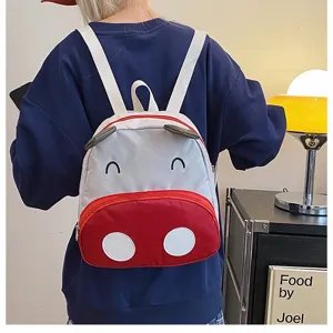 Rückansicht eines süßen rot-weißen Cartoon-Kuh-Rucksacks für Kinder in Wohnumgebung