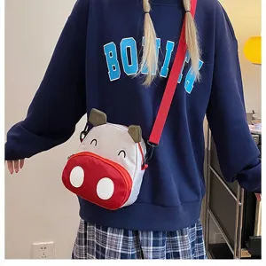 Süße Umhängetasche im Kuh-Design am Modell mit lässigem Schul-Outfit getragen