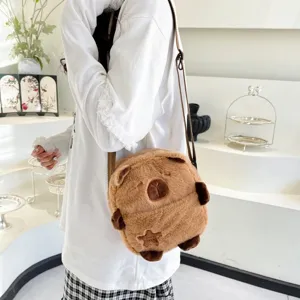 Détail d'un joli sac à bandoulière en peluche Capybara marron porté par un mannequin en salle