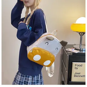 Niedlicher Cartoon Kuh Kinderrucksack getragen von Model in gemütlichem Zimmer