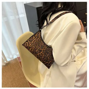Vintage leopard print underarm bag shown on a model in a stylish indoor setting.