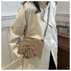 Stijlvolle hartvormige crossbodytas met vleermuisvleugels in beige met gothic veterdetails.