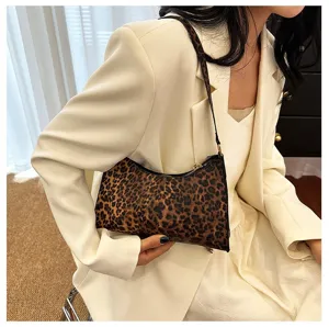 Fashionable leopard print underarm bag styled with a white blazer for a chic look.