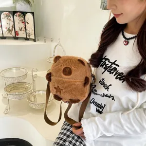 Vue détaillée d'un joli sac bandoulière en peluche capybara marron porté par un mannequin