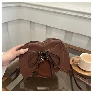 Esthetische bruine hartvormige crossbodytas met vleermuisvleugels en vetersluiting.