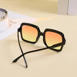 Fashionable oversized square sunglasses for women with orange gradient lenses and black frames