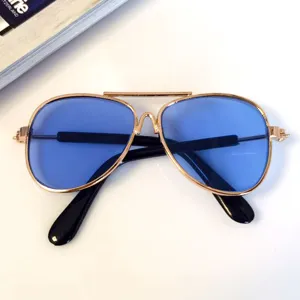 Macro view of blue lens pet aviator sunglasses with high-quality gold metal frame.