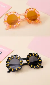 Macro view of flower-shaped children's sunglasses available in black and orange frames