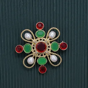 Detail macro view of a vintage Baroque brooch with red and green stones and pearls