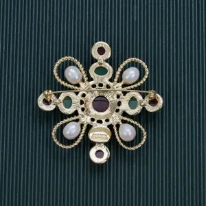 Macro back view of vintage Baroque brooch showing pearls and AMORITA BOUTIQUE brand stamp